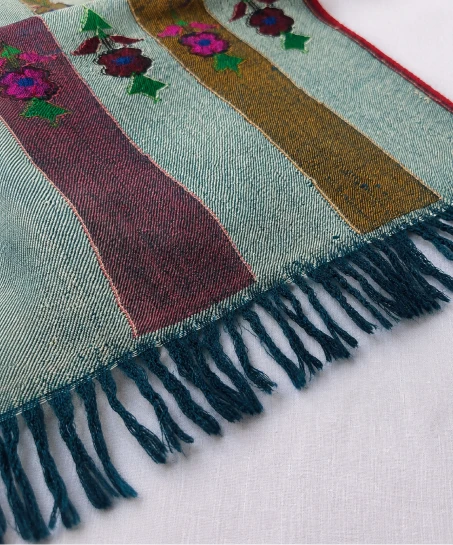 Close-up of the handcrafted Kashmiri shawl featuring decorative striped woven borders, floral accents, and neatly finished tasseled fringes.