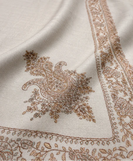 Close-up of the handcrafted Kashmiri shawl featuring intricate floral embroidery, decorative border patterns, and the smooth, luxurious woven fabric.