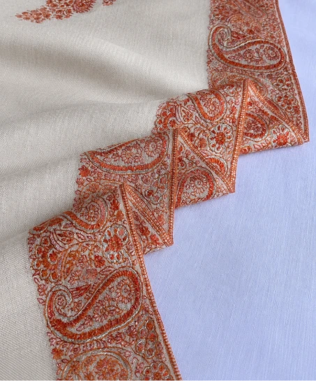 Close-up of the handcrafted Kashmiri shawl highlighting intricate paisley embroidery, decorative border detailing, and the soft woven texture.