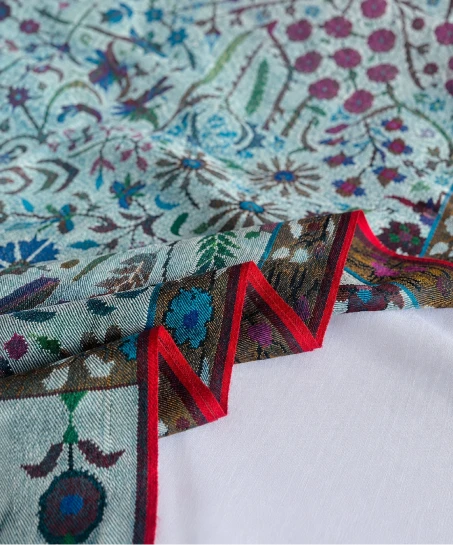 Close-up of the handcrafted Kashmiri shawl highlighting intricate woven floral motifs, decorative border detailing, and the soft, luxurious fabric texture.-1