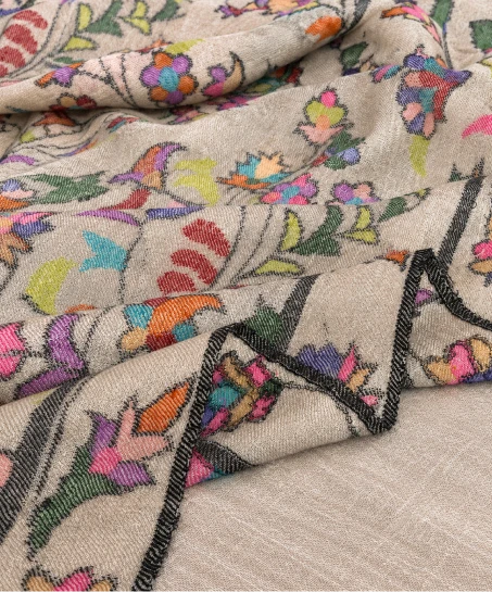 Close-up of the handcrafted Kashmiri shawl highlighting intricate woven floral motifs, decorative lattice patterns, and the soft, luxurious fabric texture.