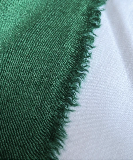 Close-up of the handcrafted Kashmiri shawl showing the soft woven fabric, natural texture, and finely finished fringed edge.