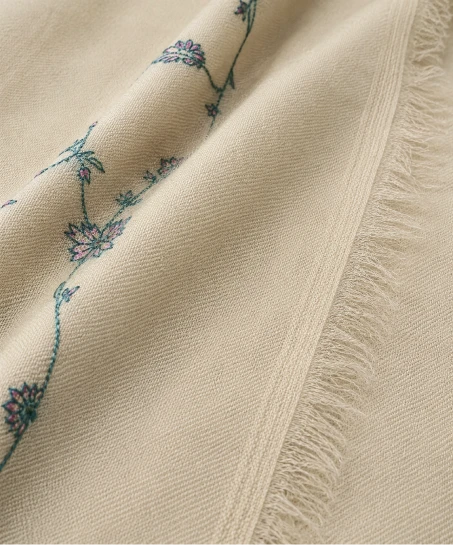 Detailed view of the Kashmiri shawl showcasing delicate floral embroidery, smooth woven fabric, and finely finished fringed edges.