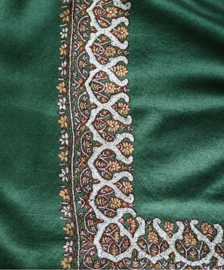 Detailed view of the Kashmiri shawl showcasing elegant floral embroidery along the border with fine threadwork and smooth fabric.