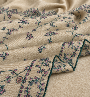 Close-up of the handcrafted Kashmiri shawl highlighting intricate floral vine embroidery, decorative blue border detailing, and the soft woven texture.